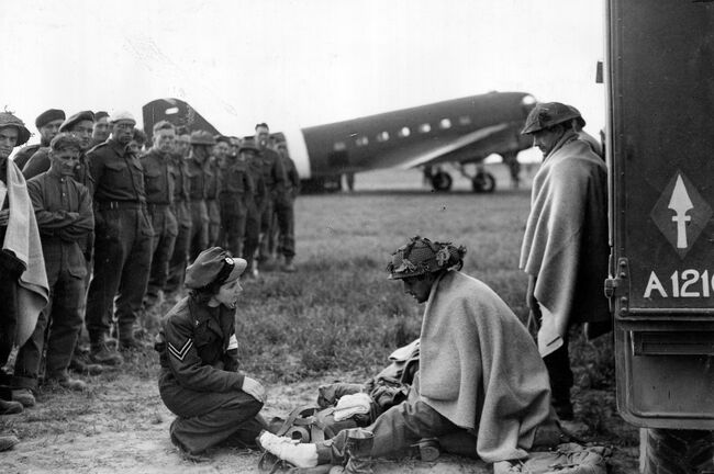 Corporal Lydia Alford, a WAAF nursing orderly, tending to wounded British soldiers at B2/Bazenville airfield in Normandy, 13 June 1944. This was the first day casualty flights had carried WAAF orderlies.