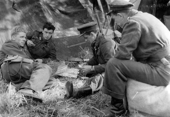 The inevitable card game between sorties for pilots of 414 Squadron RCAF at B2/Bazenville, Normandy, on 16 June 1944. Left to right:- Flight Lieutenant J Seaman of New Brunswick; Flying Officer JA Roussell of Quebec; Flying Officer L May of Toronto and Flying Officer J Younge of Ontario.