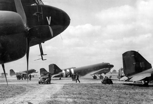 Douglas Dakota IIIs of 46 Group at B2/Bazenville, Normandy, loading casualties for evacuation from B2/Bazenville to the United Kingdom, 17 June 1944. Identifiable aircraft include KG432/H of 512 Squadron (centre), and KG320/B1 of 575 Squadron RAF (extreme right).