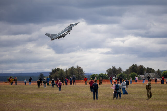Typhoon plane air display in sky with crowds watching on grass