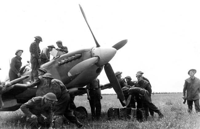 Ground crew refuel and re-arm one of the first Supermarine Spitfires to land in France, a Mark IX of 441 Squadron RCAF, at the advanced landing ground at B3/Ste-Croix-sur-Mer, Normandy, on the afternoon of 10 June 1944.