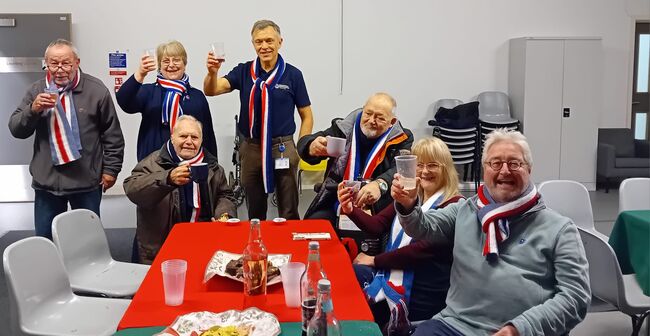 Group of veterans and Sue Powell raising glasses in toast