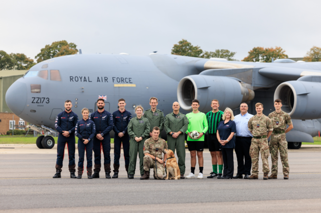 An image of RAF personnel standing in front of an air craft on a landing strip.
