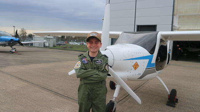 Jacob in front of plane wearing flying suit