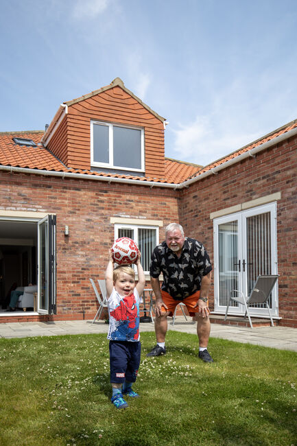 Grandfather and grandson playing football