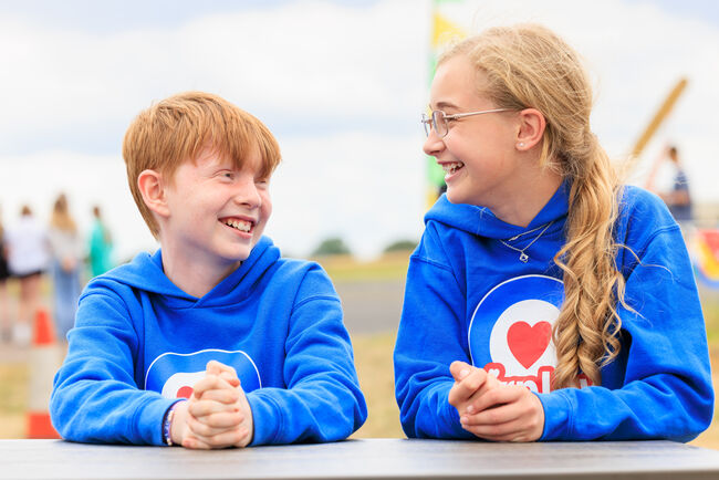 Boy and girl in blue Airplay hoodies smiling at each other