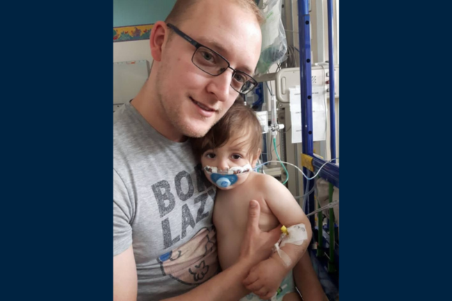 John holding Henry in hospital