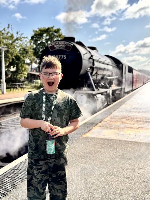 Logan standing in front of steam train