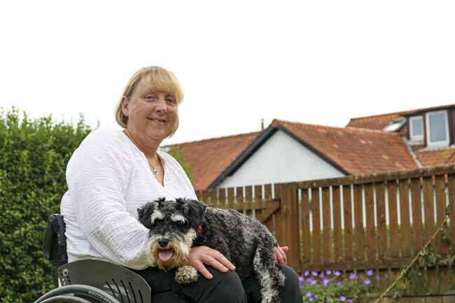 Fund ambassador Joanna Martin sat in garden with her dog