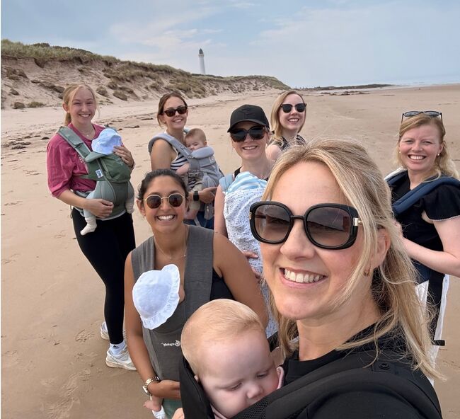 Lossie mums smiling with babies in slings standing on beach