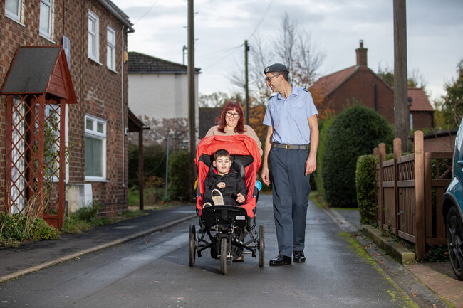 Family walking with son in adapted buggy