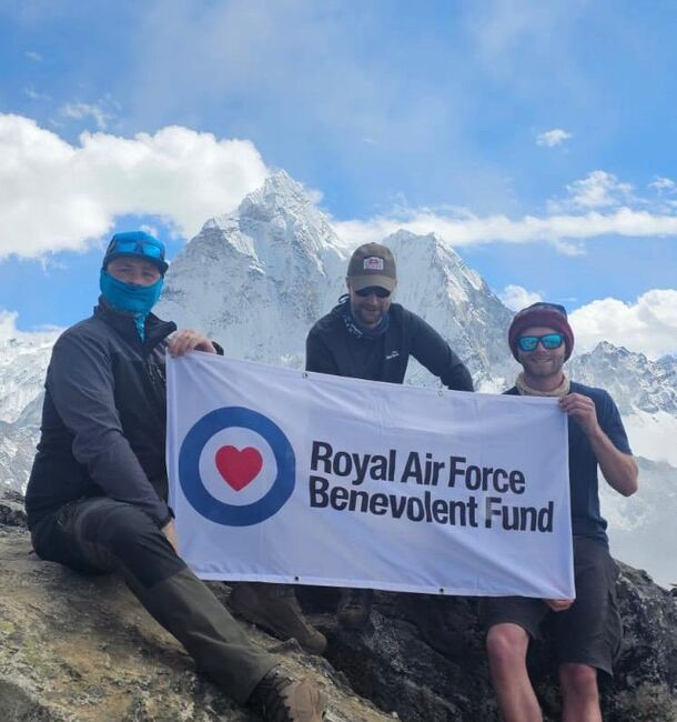 Rowan and two others on Mount Everest climb holding Fund banner