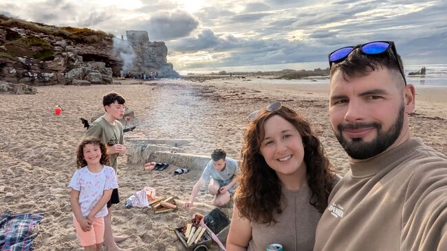 Family on beach with bonfire