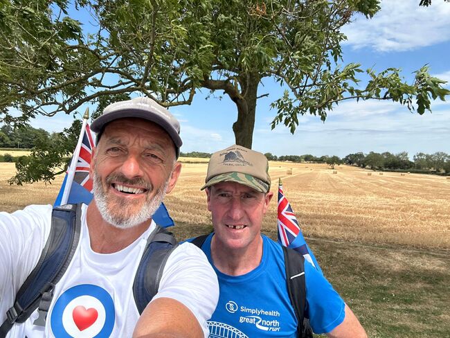 John and Simon smiling in front of field