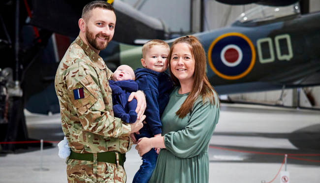 RAF wife Amileigh Salt and her husband, with their two young children, stood in front of a spitfire.