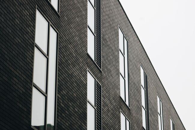 Black and white image of the front of a brick office building.